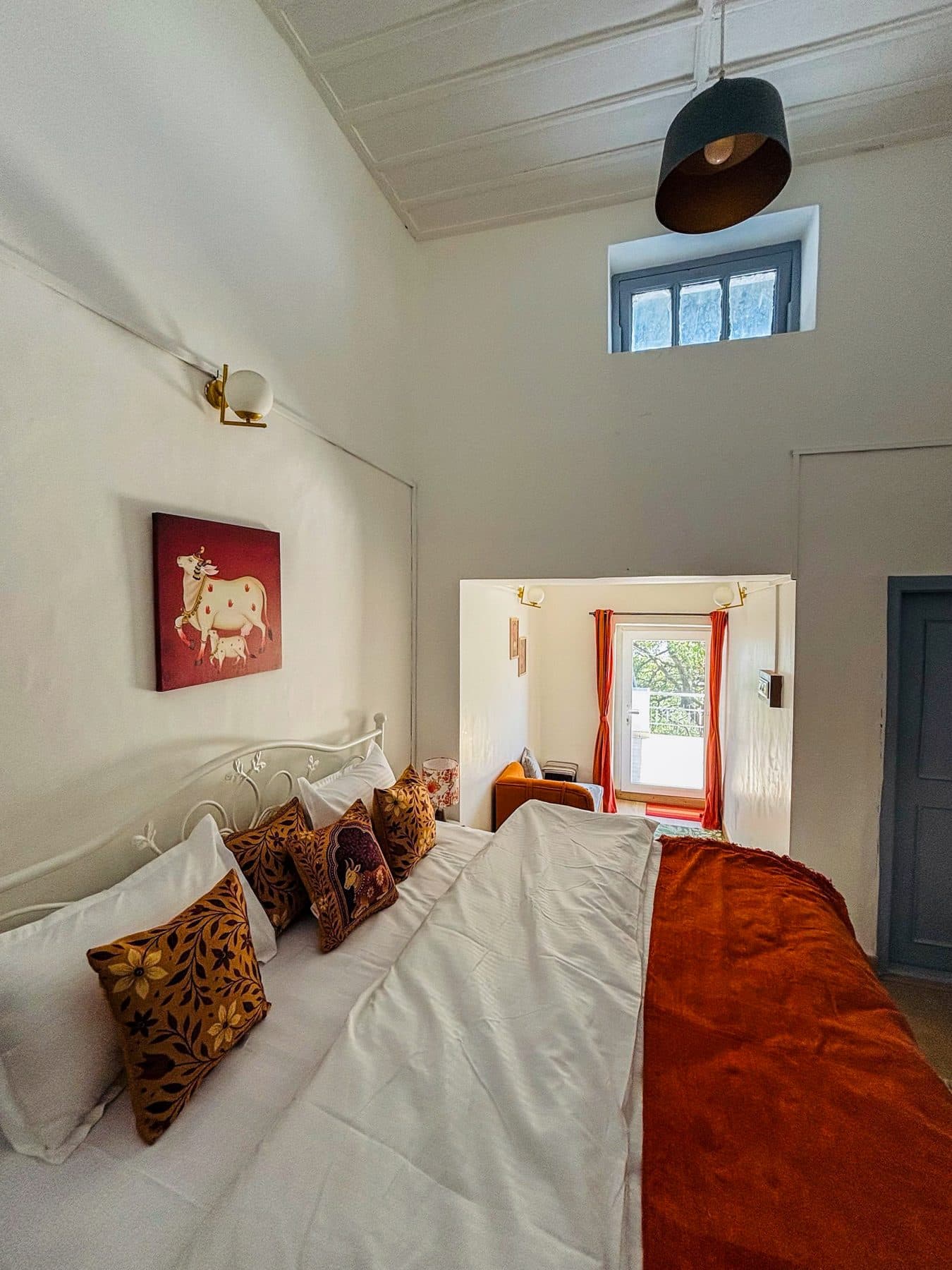 Room 02 at Shail Shikhar Cottage, Mussoorie: a cow-and-calf Pichwai over the bed and a saffron throw