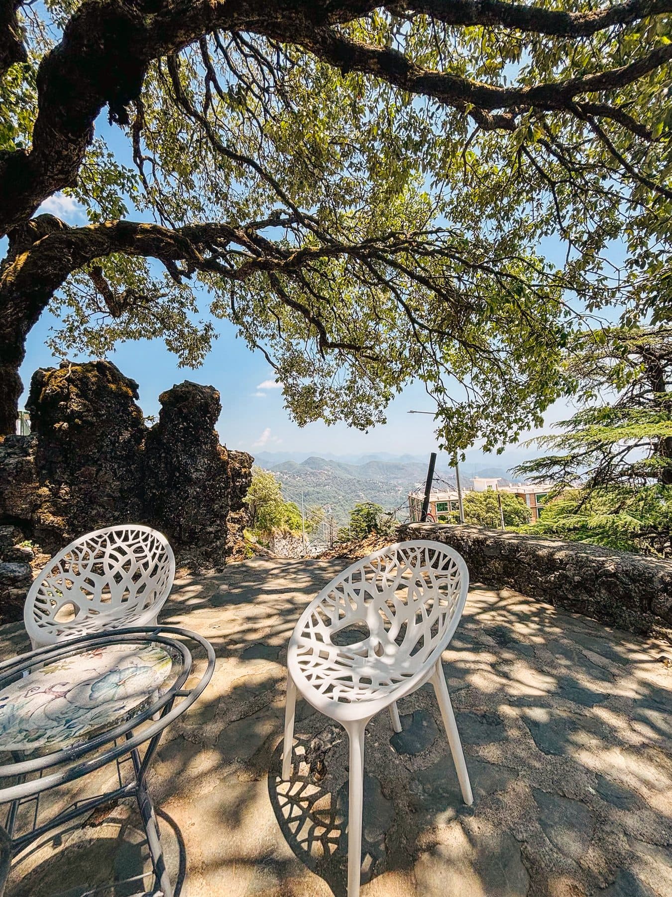 Two chairs by the rocks in the rock garden on the first floor, under the oak, at Shail Shikhar Cottage, Mussoorie