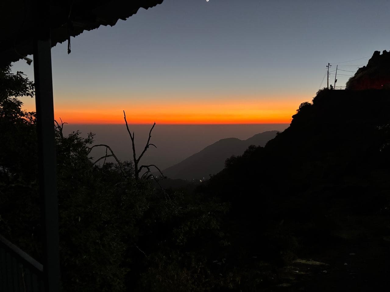 Orange dusk above the dark valley viewed from Shail Shikhar